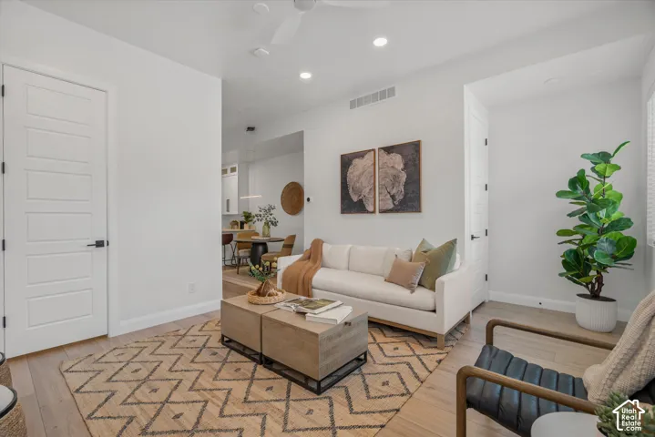 Light-filled living area featuring wood-finish flooring, recessed lighting, and a neutral color palette