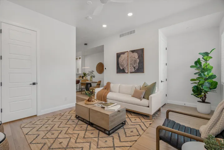 Light-filled living area featuring wood-finish flooring, recessed lighting, and a neutral color palette