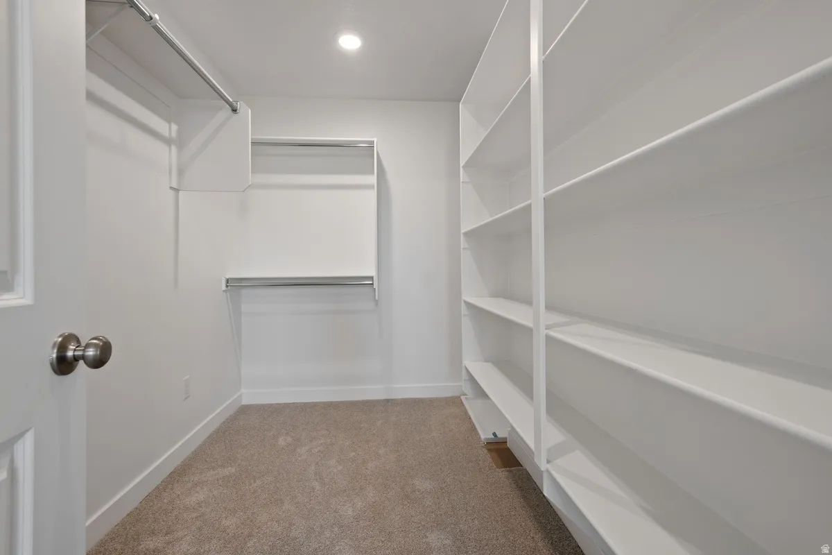 Built-in closet system featuring extensive shelving, hanging rods, and recessed lighting