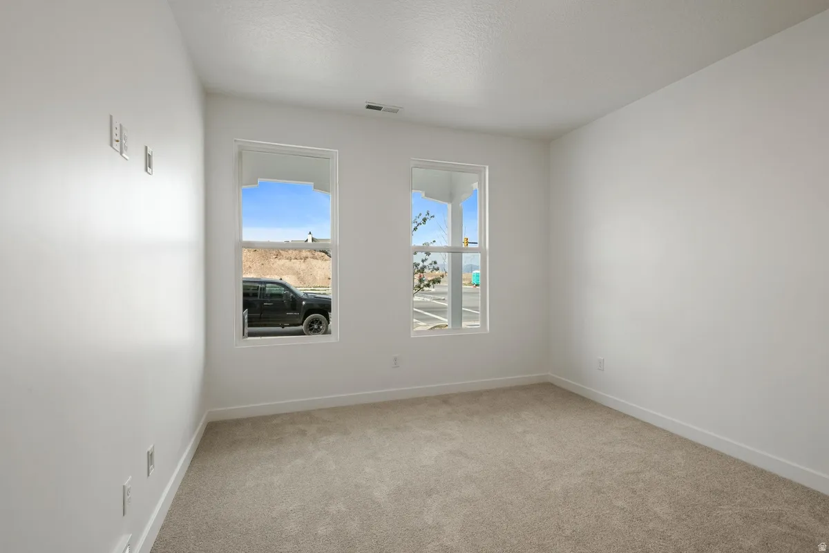 Neutral-toned carpet flooring complements light-colored walls and white trim