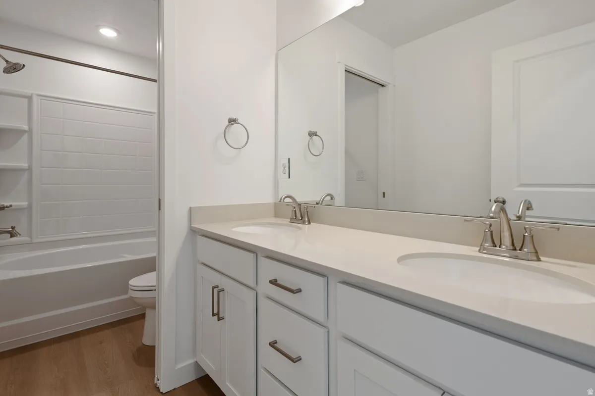 Dual vanity with white cabinetry and brushed nickel hardware, featuring a light-toned countertop and undermount sinks