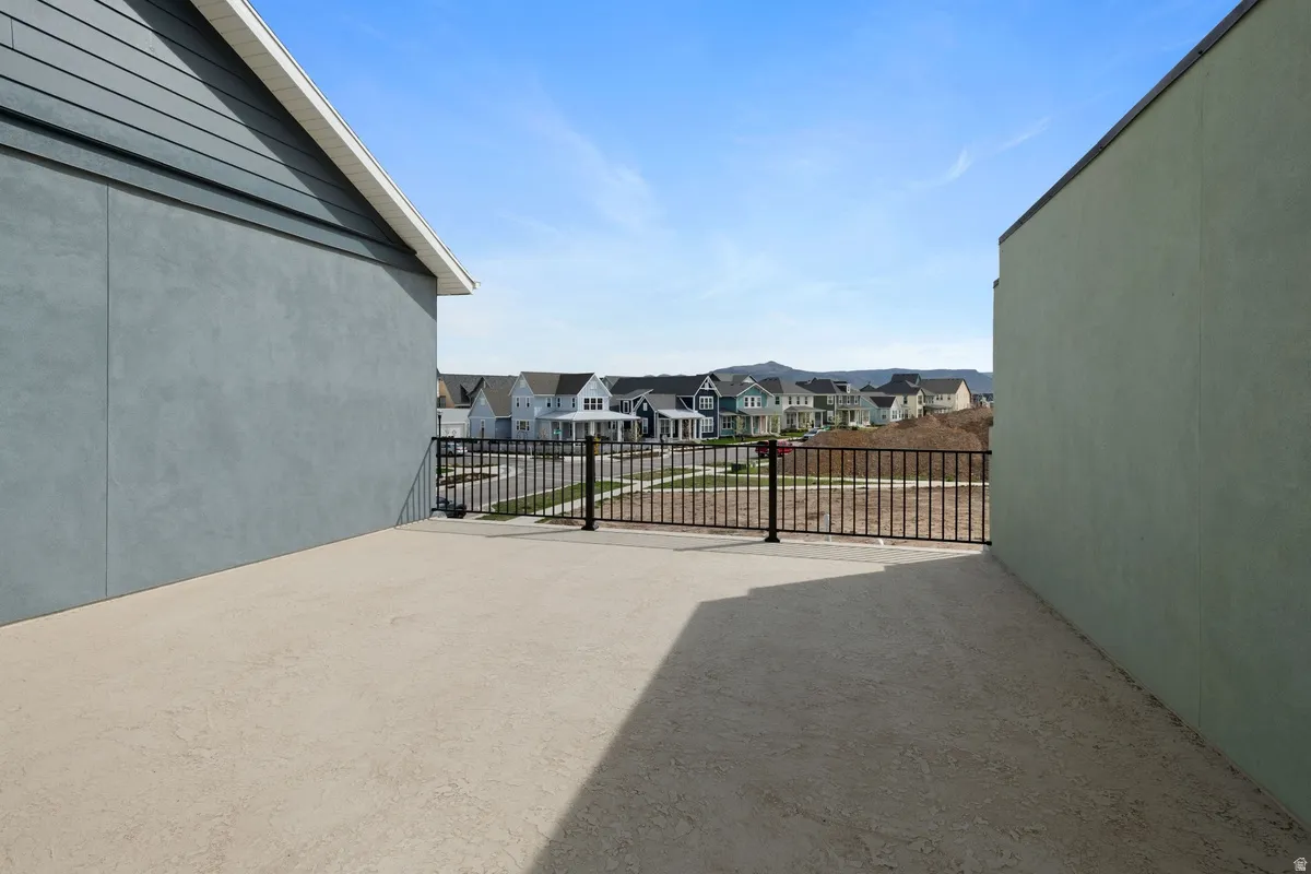 Rooftop deck featuring a textured concrete surface and black metal railing