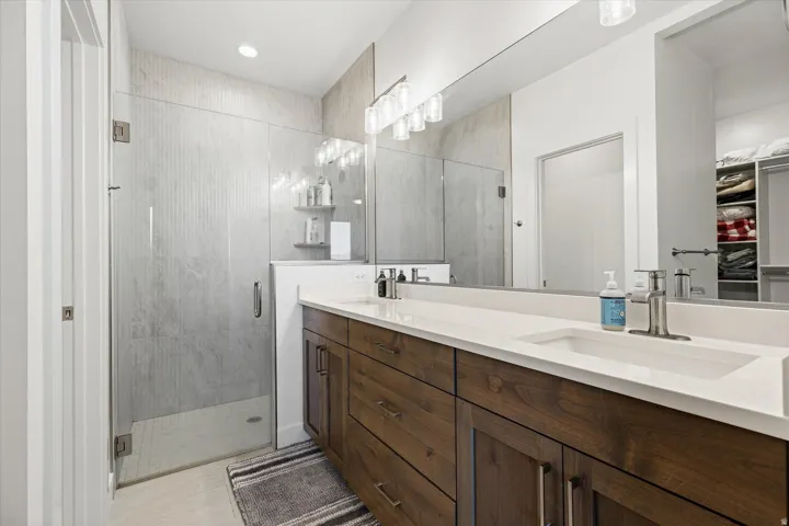 Double vanity with white solid surface countertops, integrated sinks, and wood-finish cabinetry