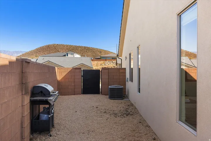 Low-maintenance side yard featuring gravel landscaping, a privacy block wall, and an exterior side door
