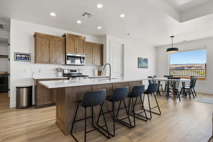 Open-concept kitchen featuring wood-finish flooring, recessed lighting, and a kitchen island with seating