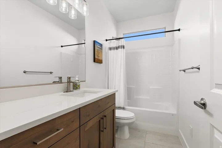 Bathroom featuring a wood-finish vanity with a white countertop and integrated sink