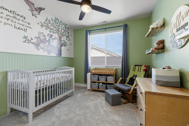 Room featuring light green walls, beadboard wainscoting, and carpet flooring