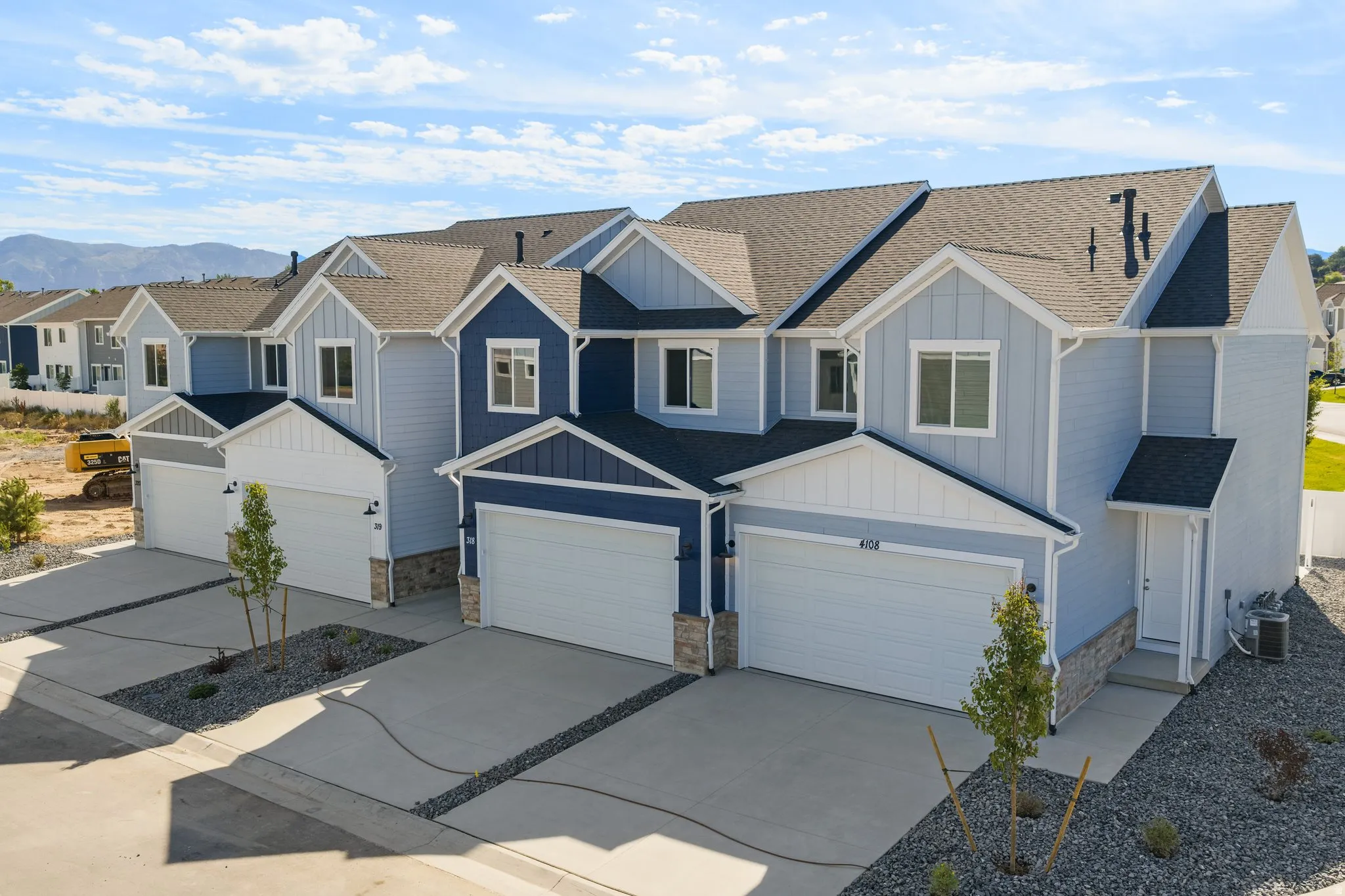 Townhome exteriors featuring horizontal siding and dark shingle roofing