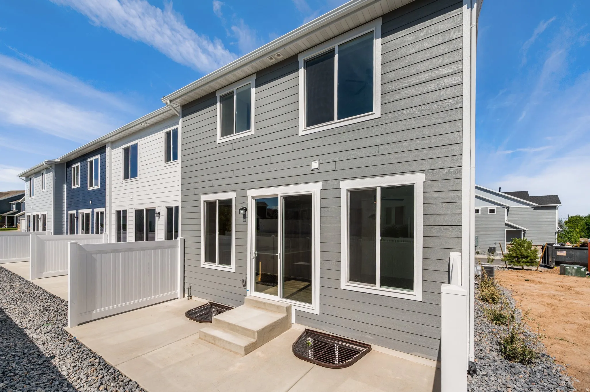 Rear exterior featuring gray horizontal siding and white trim