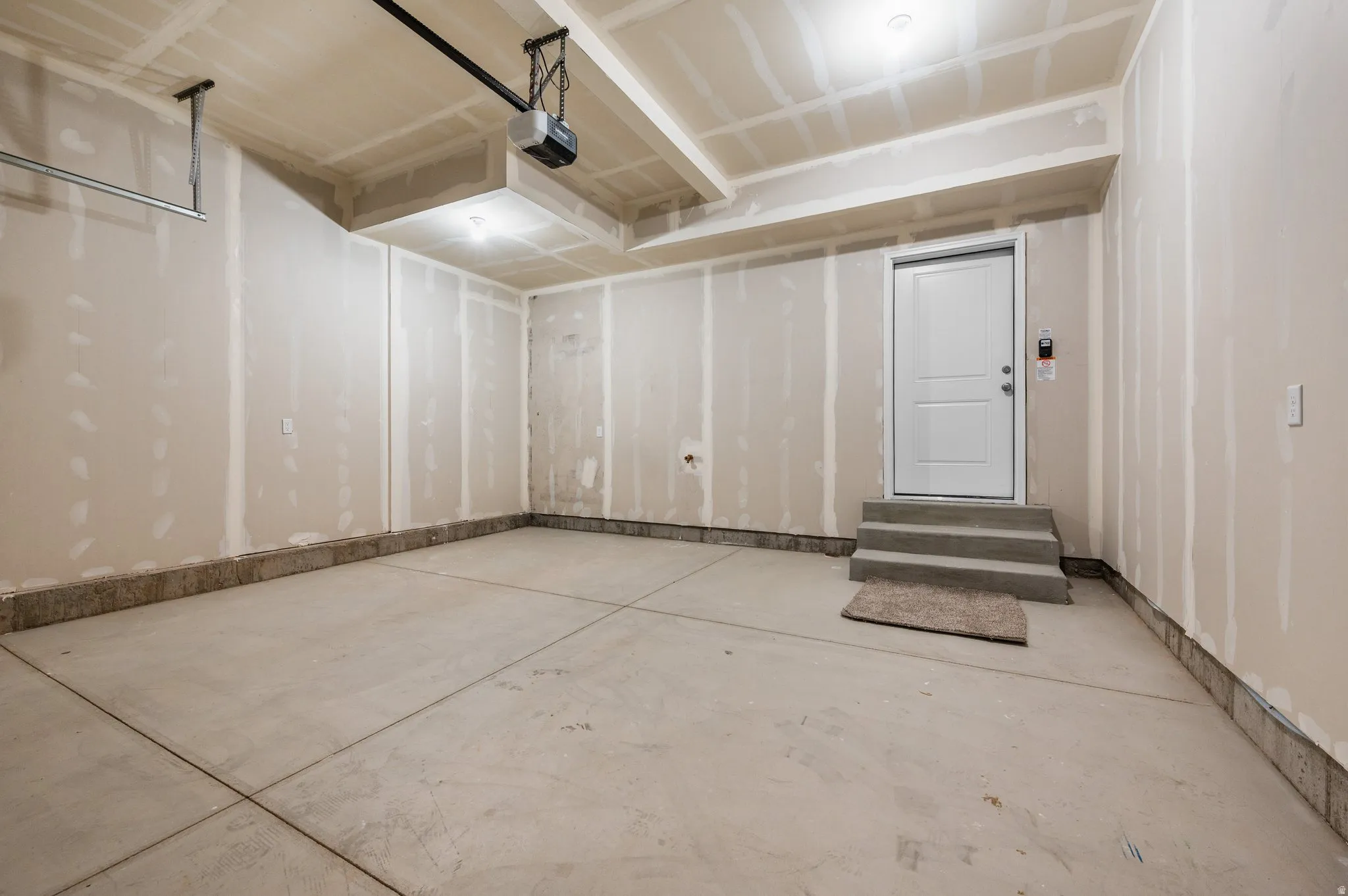 Spacious garage featuring a concrete floor, high ceilings, and an overhead garage door opener