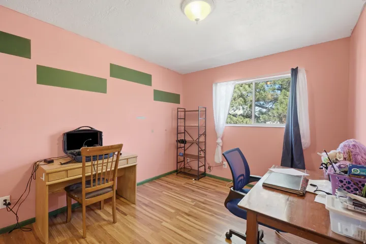 Room featuring wood-finish flooring, a double window, and a ceiling-mounted light fixture
