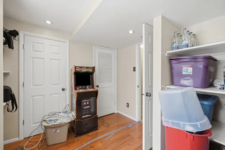 Finished lower level space featuring recessed lighting, paneled interior doors, and wood-finish flooring