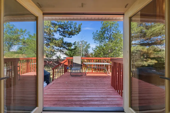 Spacious outdoor deck with red-stained wood flooring and matching railings