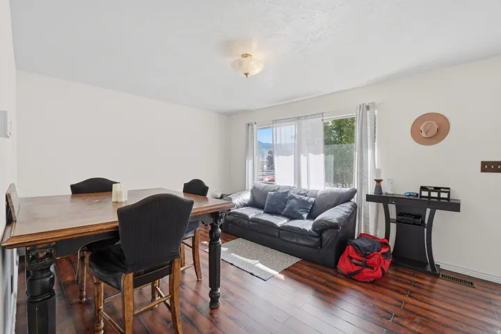 Open-concept living space featuring wood-finish flooring, a large window, and a ceiling-mounted light fixture