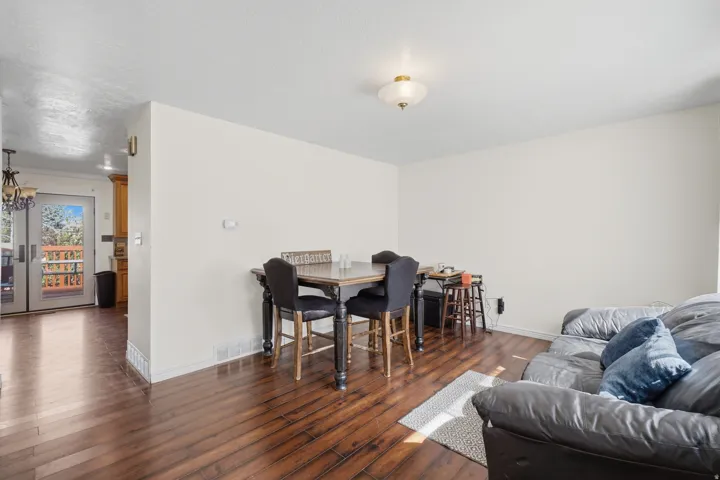 Spacious living area featuring wood-finish flooring, light-toned walls, and a ceiling-mounted light fixture