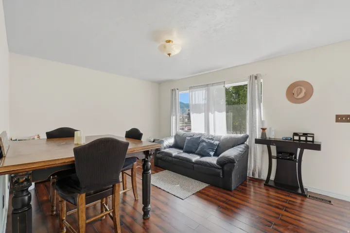 Spacious room featuring wood-finish flooring, light-toned walls, and a large window