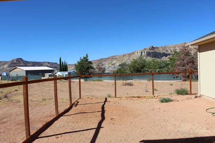 Expansive open yard with a wood-frame wire fence