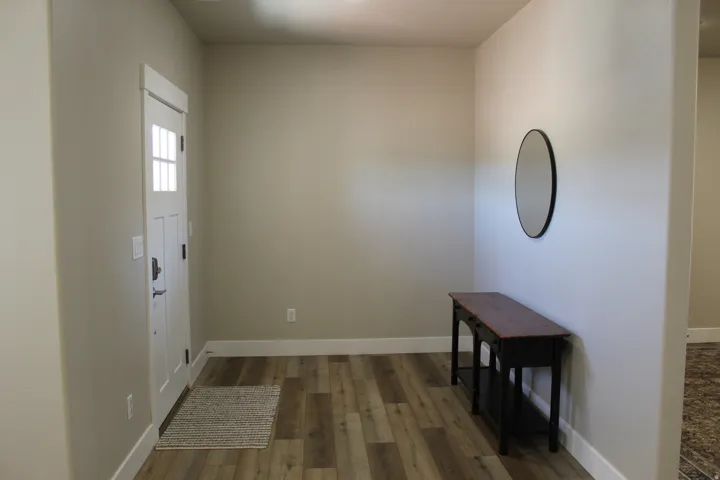 Entryway featuring wood-finish flooring, neutral wall tones, and white trim