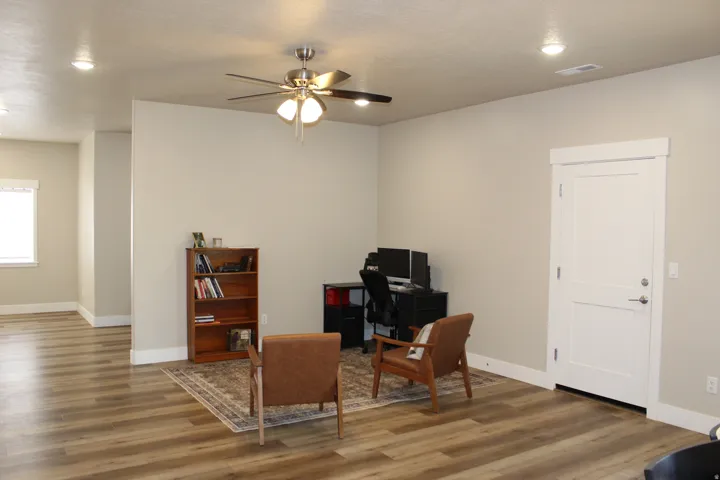 Open-concept living space with wood-finish flooring, recessed lighting, and a ceiling fan