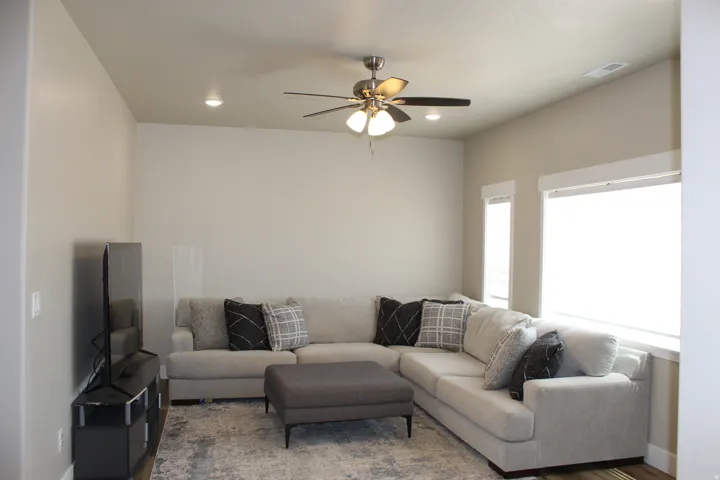Living area with wood-finish flooring, recessed lighting, and a ceiling fan