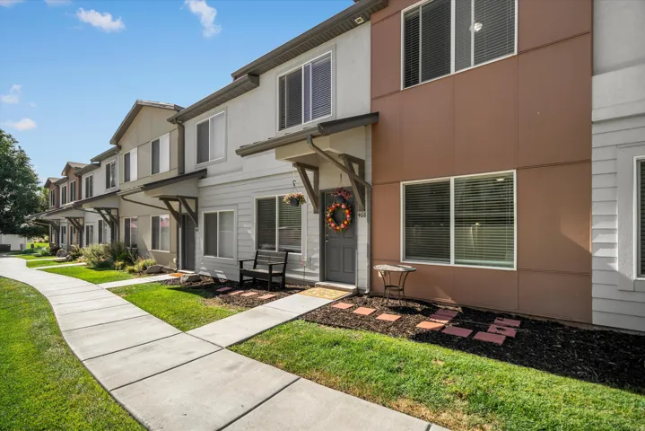Contemporary townhome exterior featuring multi-toned siding, white-framed windows, and a covered entryway
