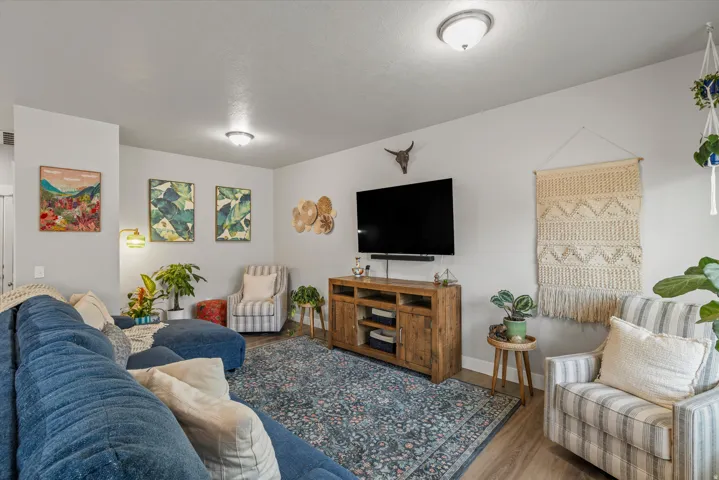 Living area featuring wood-finish flooring, light grey walls, and ceiling-mounted lighting fixtures