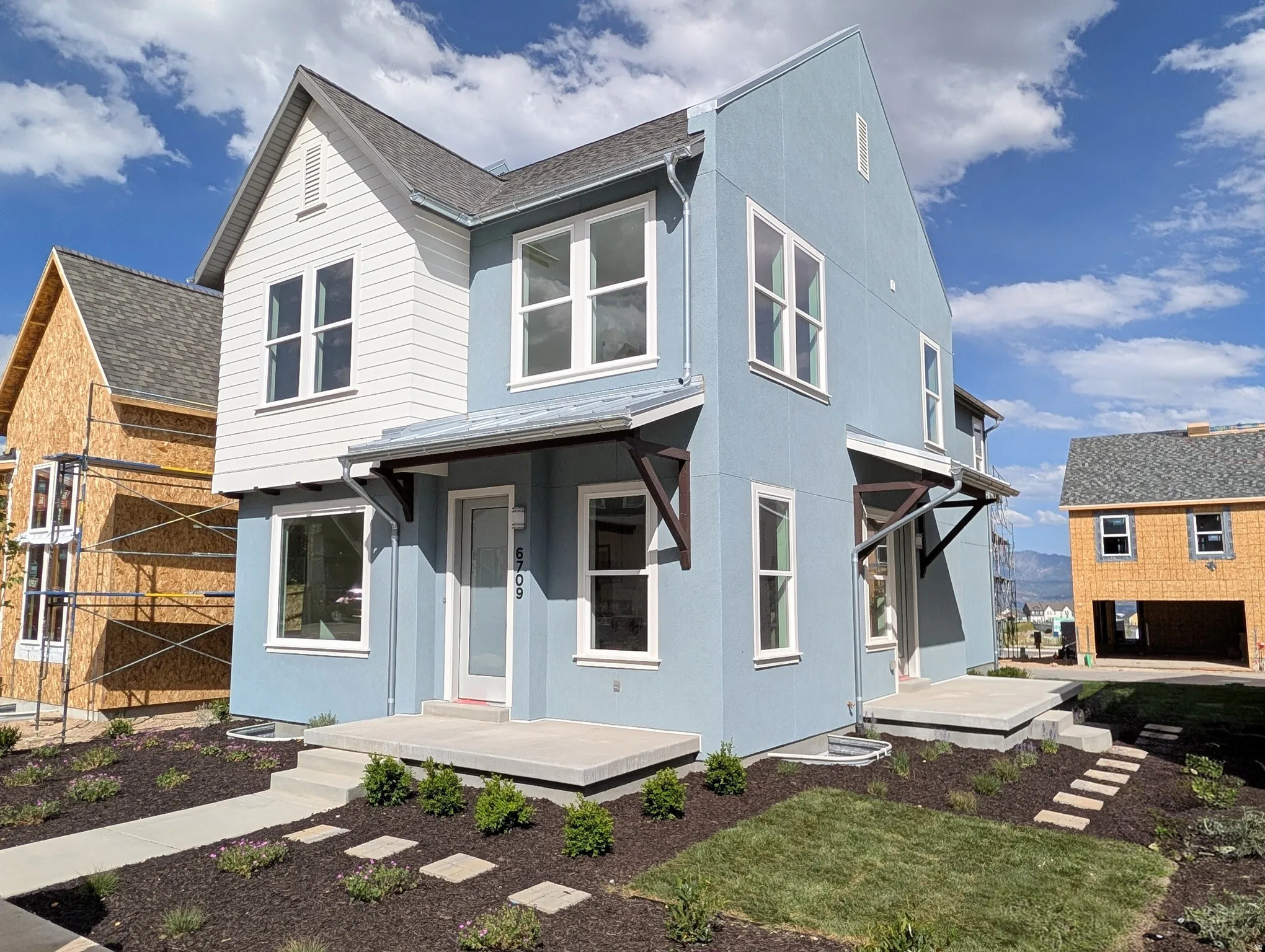 Modern-style exterior featuring a light blue facade and white horizontal siding