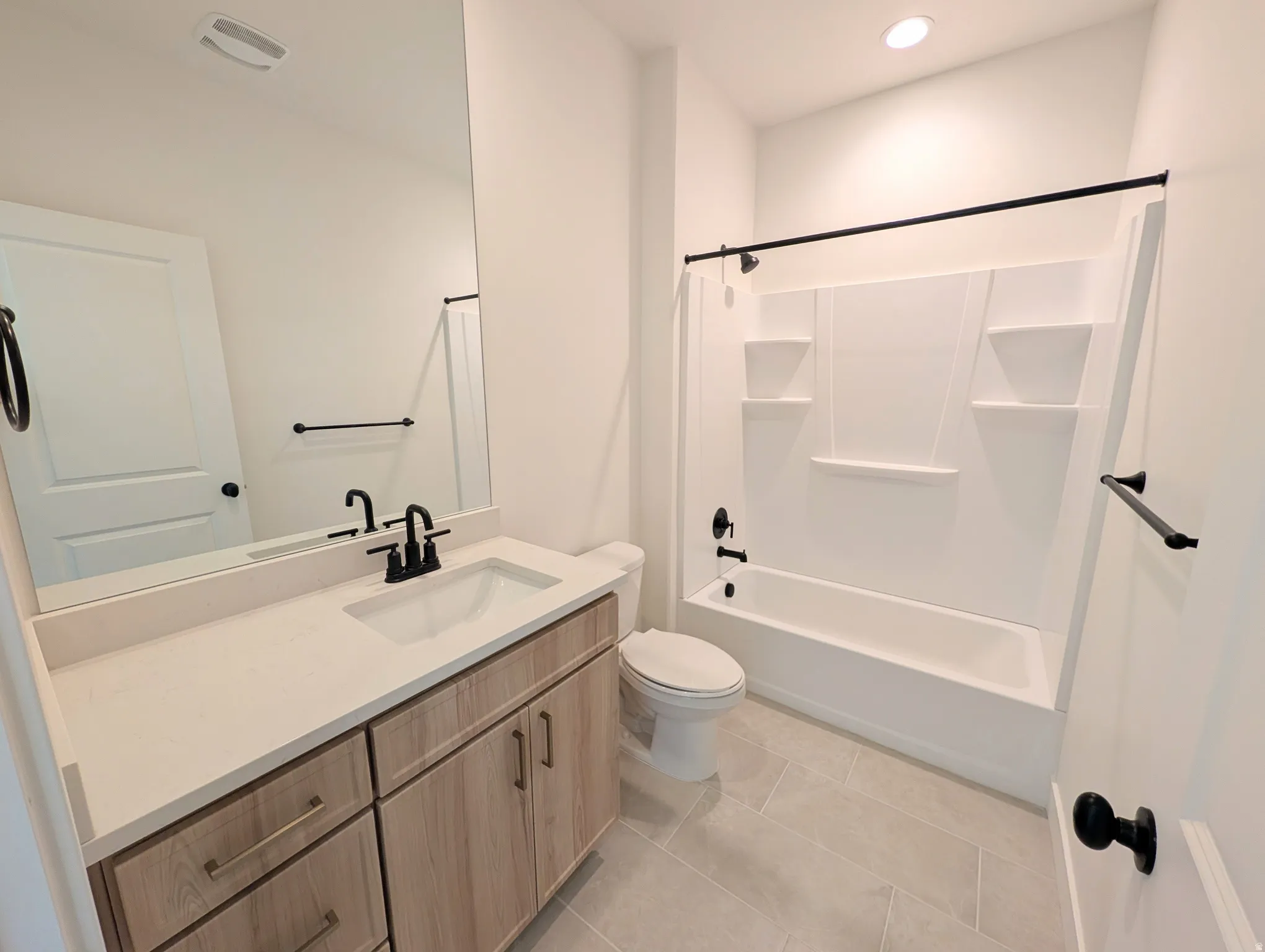 Light wood-finish vanity with a light-toned countertop and integrated sink