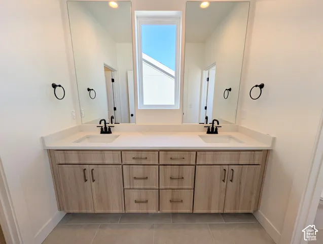 Dual floating vanities with wood-finish cabinetry, light-toned countertops, and matte black fixtures