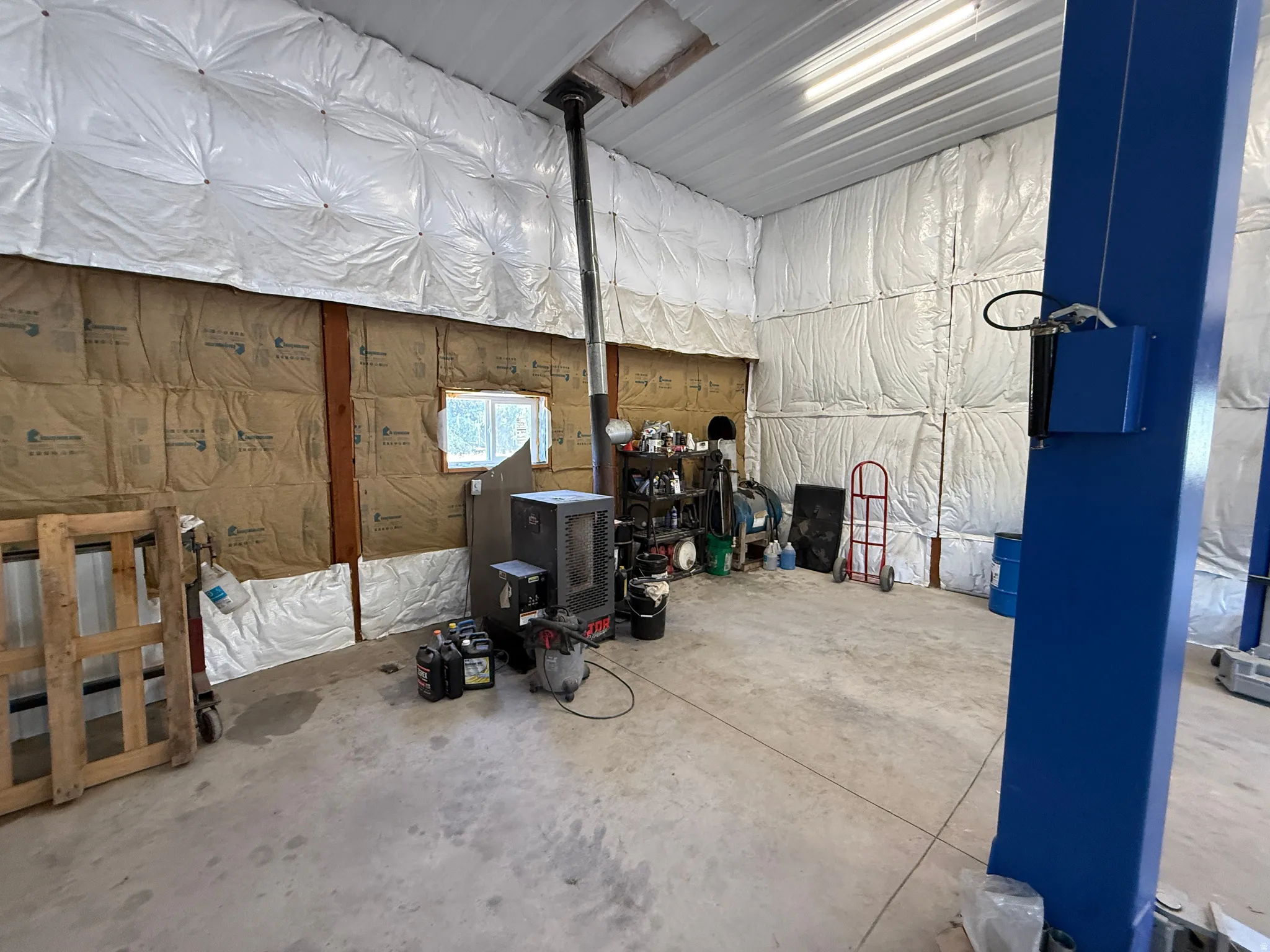 Spacious workshop featuring concrete flooring and exposed structural beams
