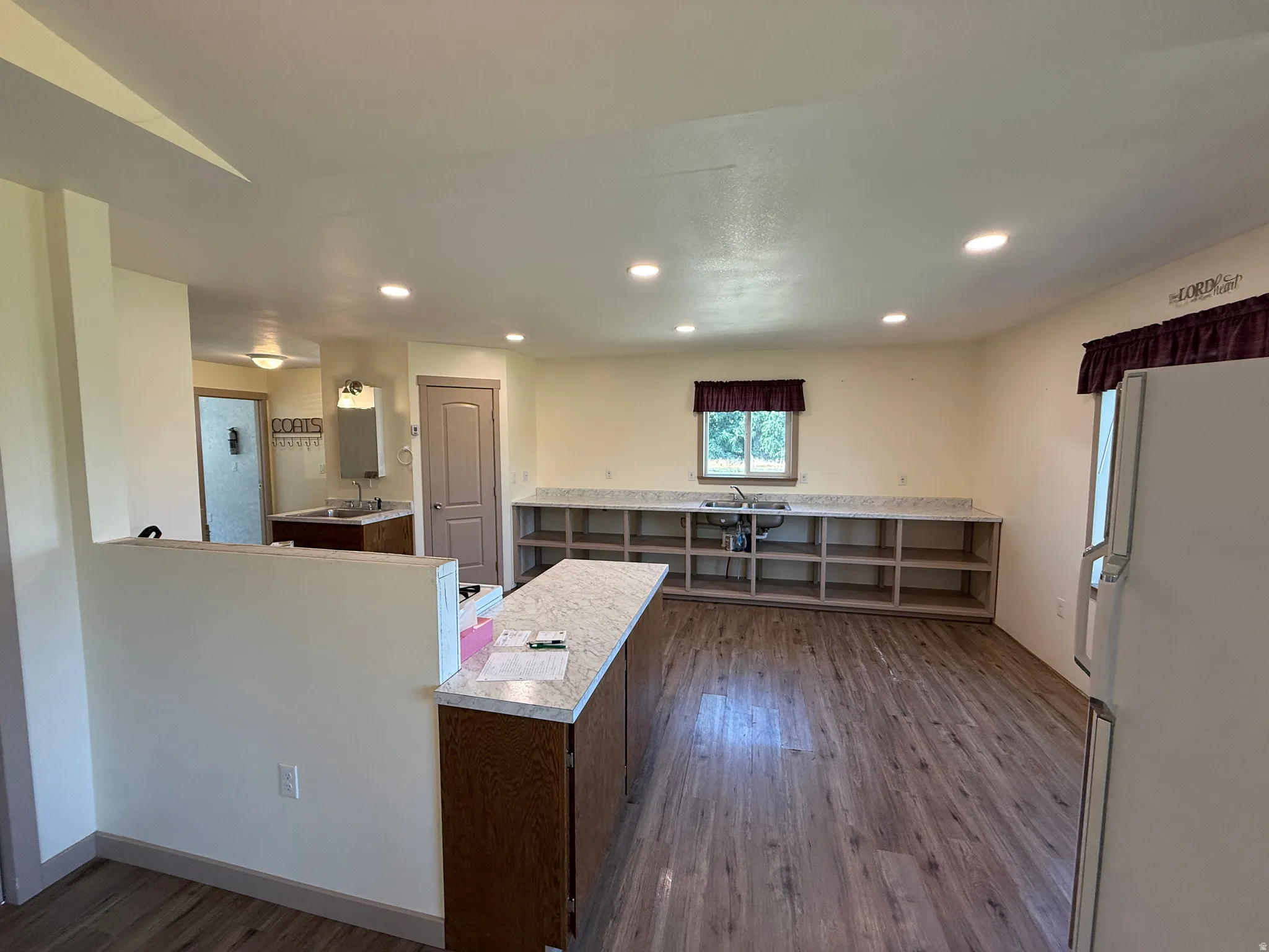 Spacious kitchen area featuring wood-finish flooring, recessed lighting, and granite-look countertops