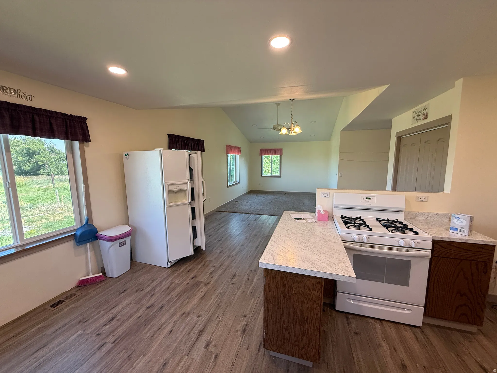 Kitchen featuring wood-finish flooring, white appliances, and light-toned countertops