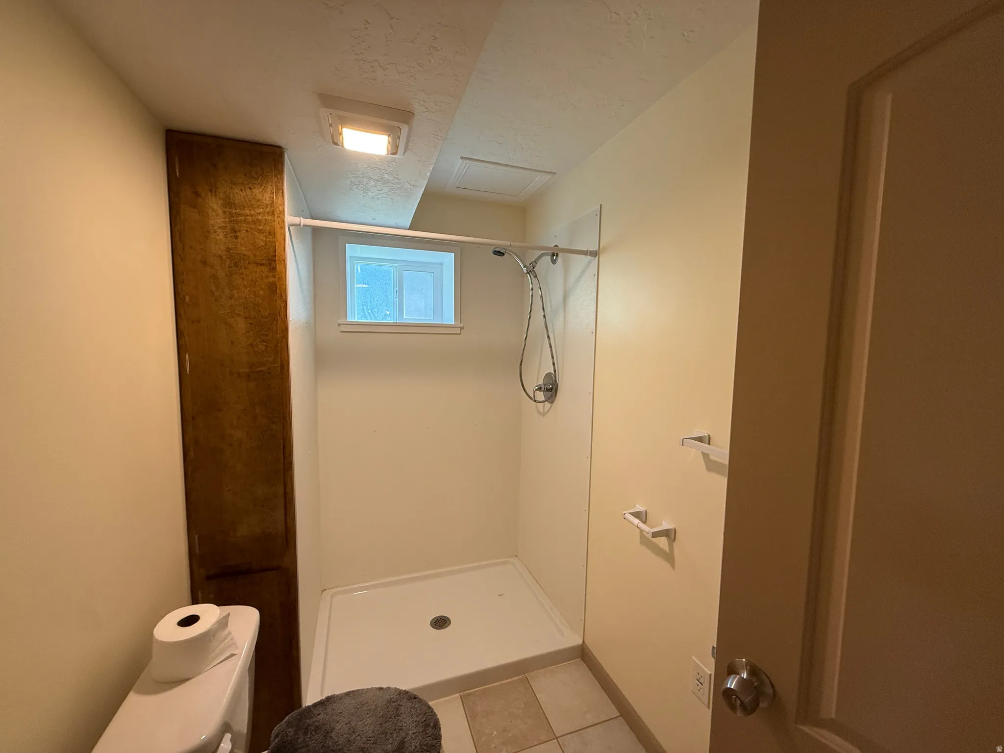 Three-piece bathroom featuring a stand-up shower with a white pan and chrome fixtures