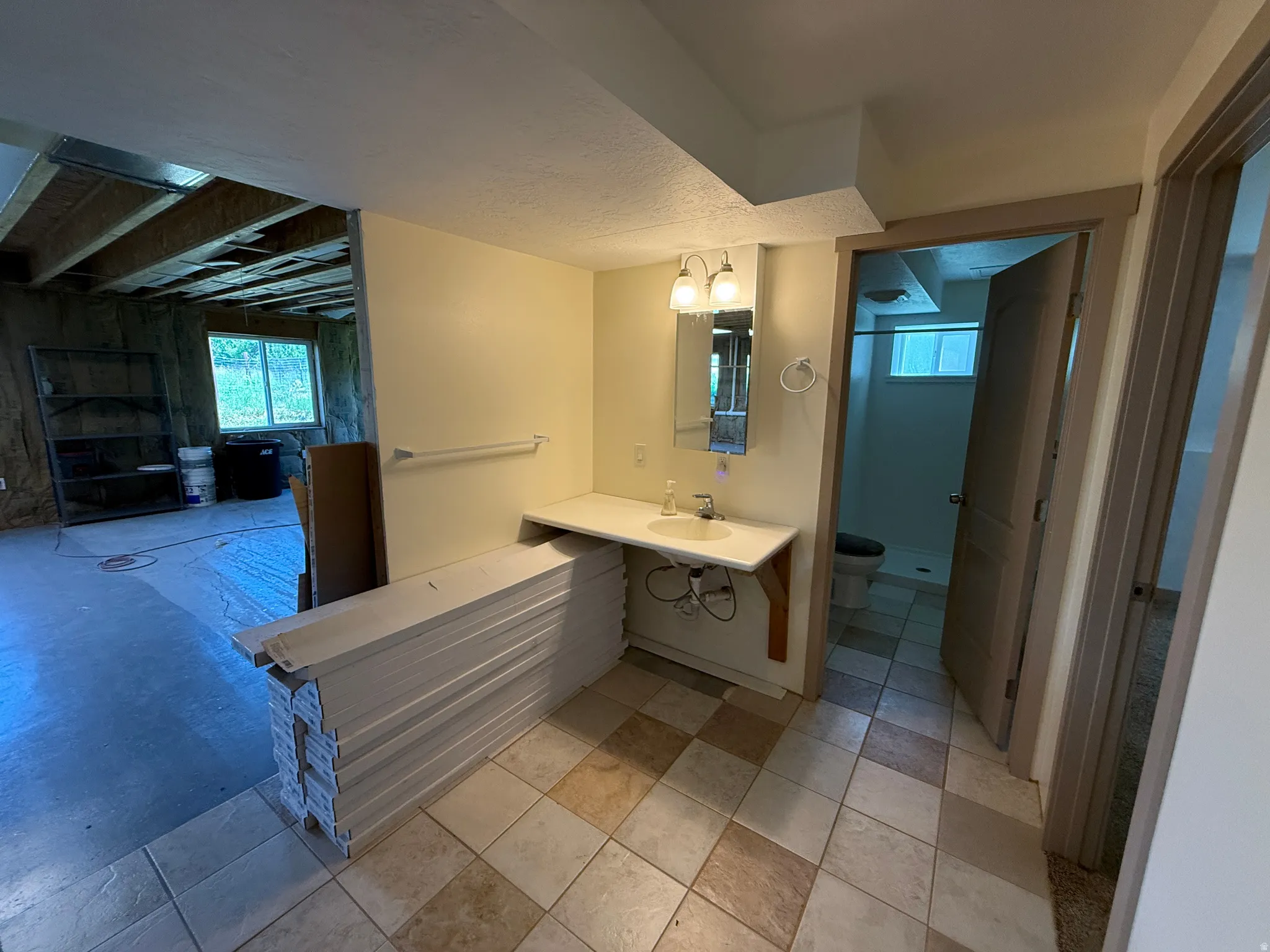 Bathroom vanity area featuring a rectangular sink, wall-mounted faucet, and overhead lighting fixture
