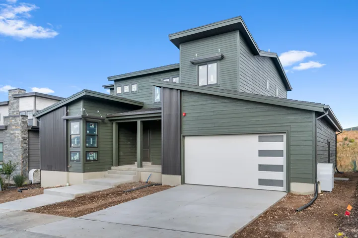 Contemporary architecture with multi-level rooflines and dark green siding