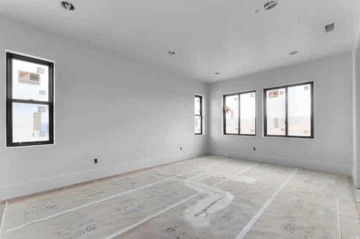 Recessed lighting, multiple windows, and crisp white walls