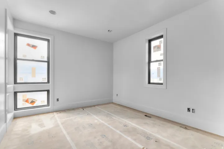 Crisp white walls, recessed ceiling lighting, and large windows with dark trim