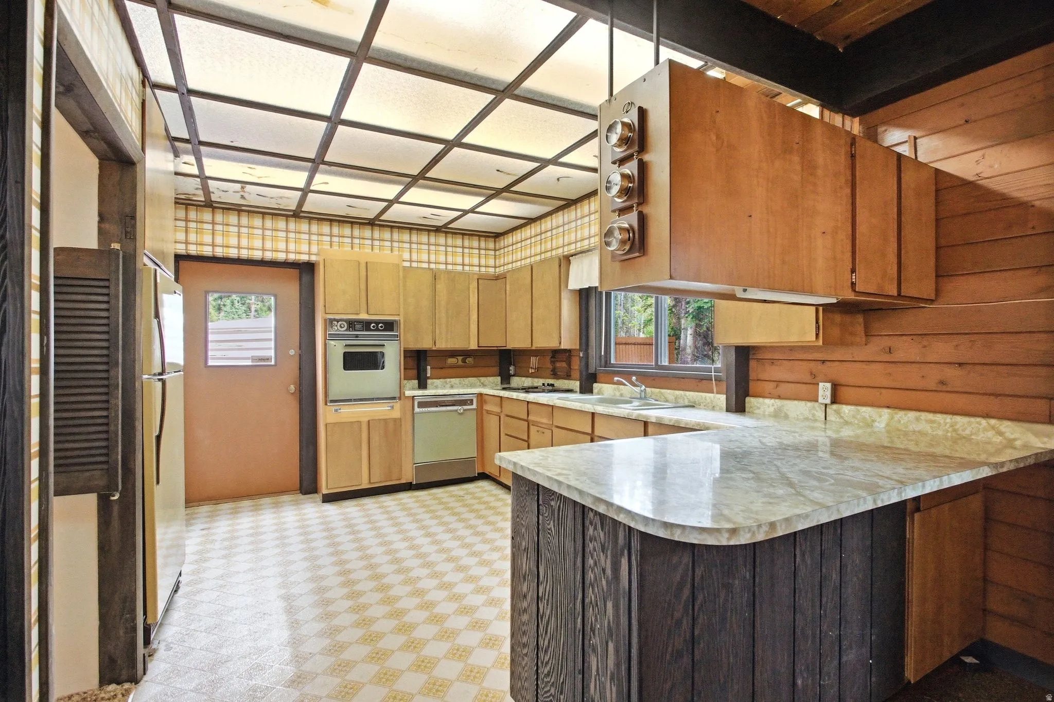 Kitchen featuring wood cabinetry, built-in oven, and a double basin sink