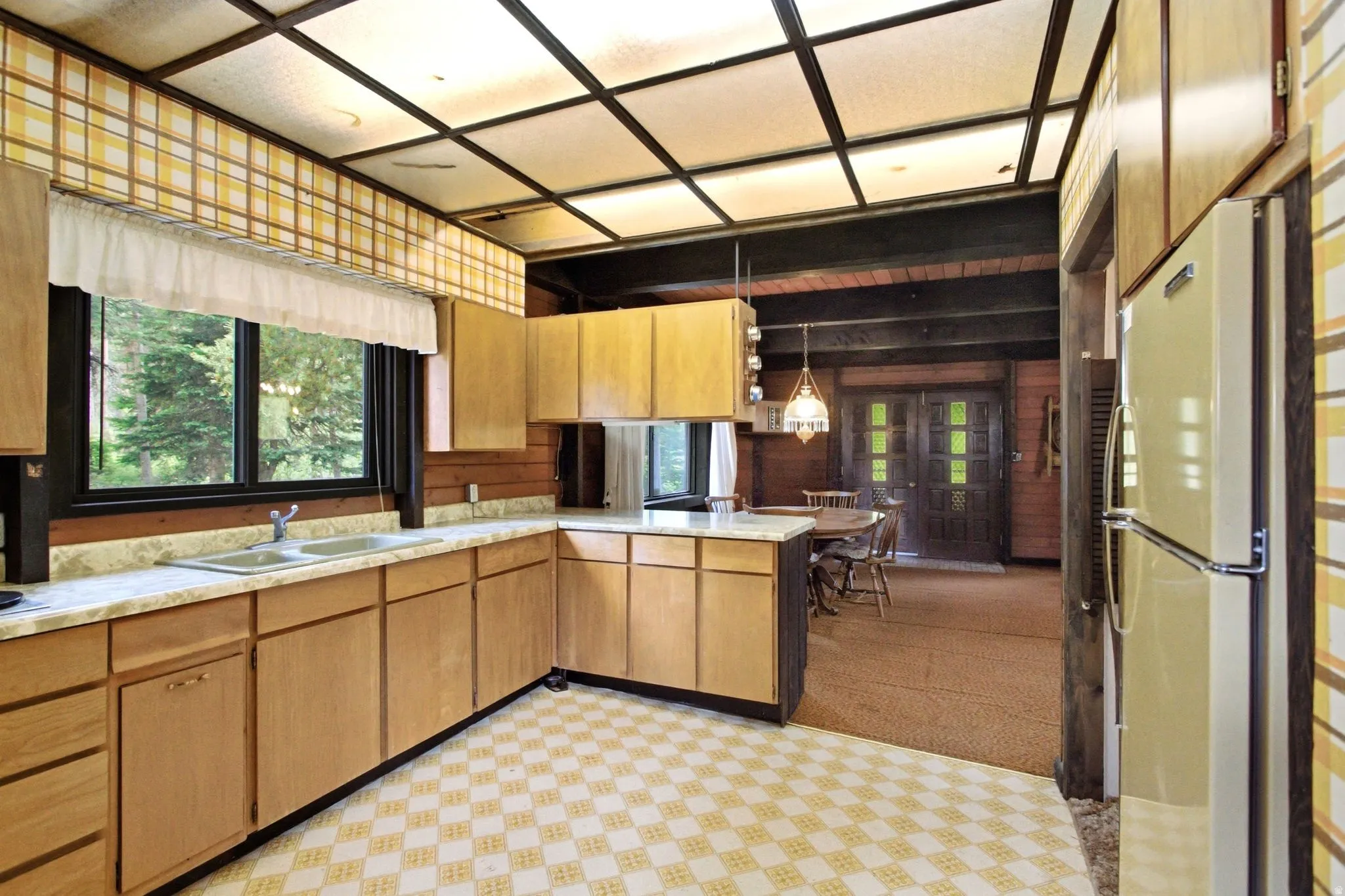 Kitchen featuring wood-finish cabinetry, a double basin sink, and a large window