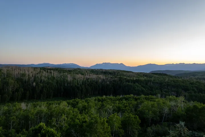 Expansive forested landscape with distant mountain ranges under a clear sky