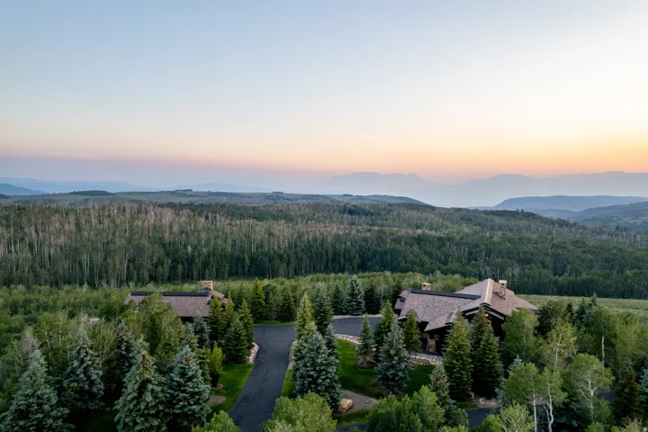 Sprawling property featuring two distinct structures with natural wood siding and shingle roofs