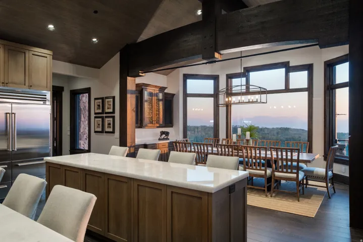 Gourmet kitchen with an expansive island, stainless steel refrigerator, and wood-finish cabinetry
