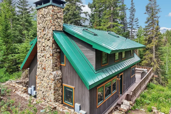 Contemporary cabin exterior with a striking green metal roof
