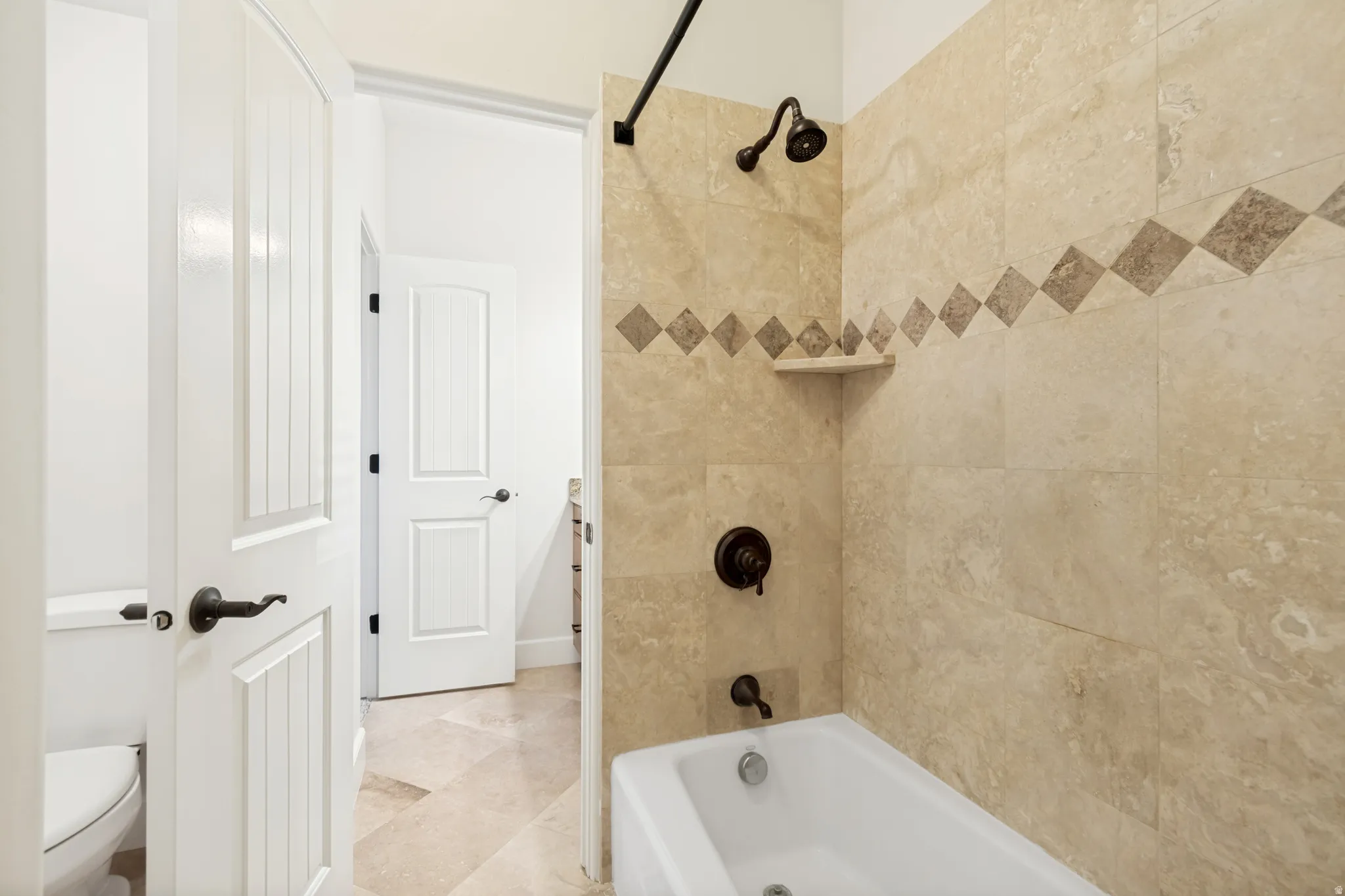 Jack and Jill bathroom for upstairs bedrooms #2 and 3, featuring light-toned tiled walls with a decorative accent band