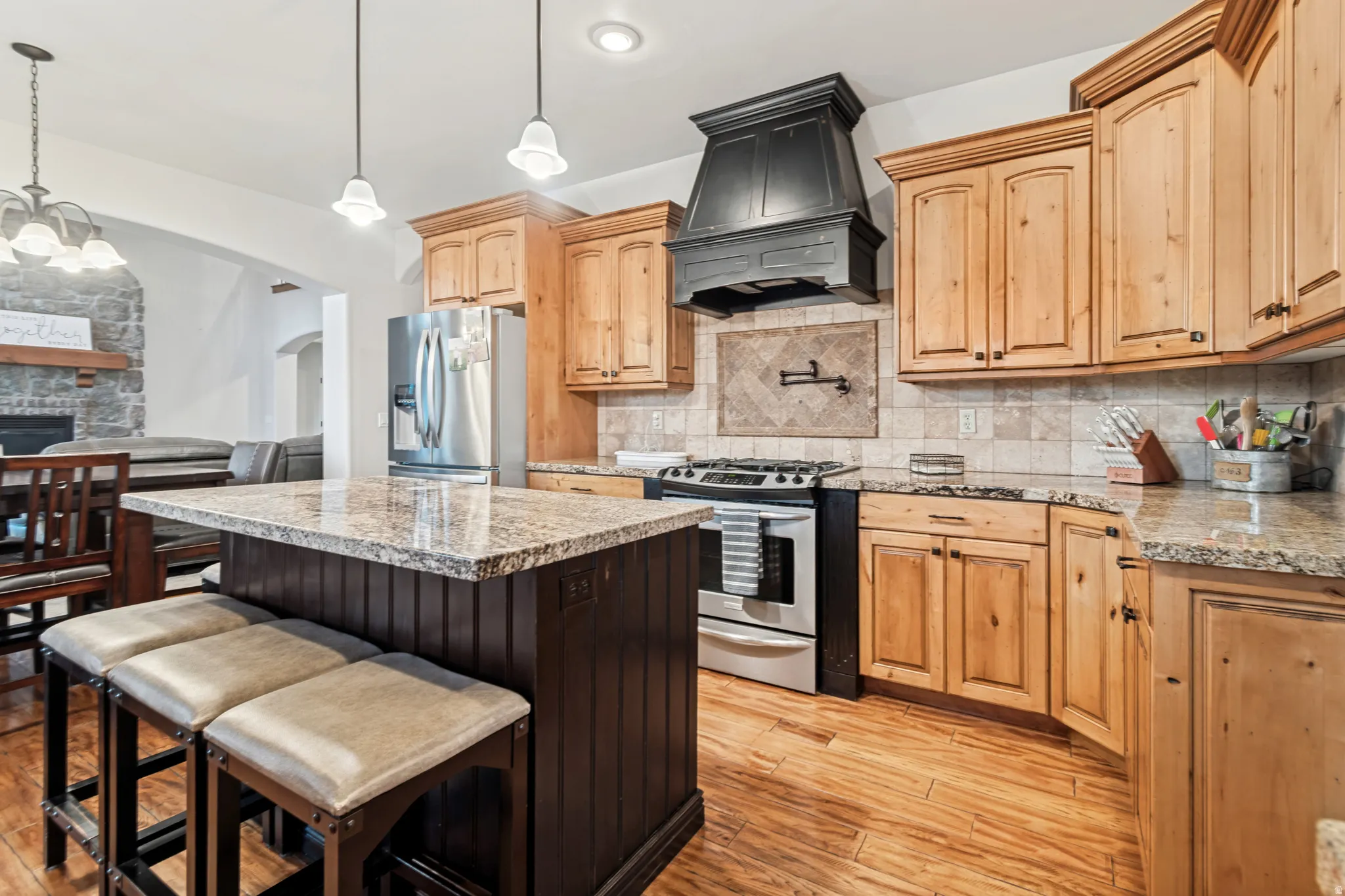 Open-concept kitchen featuring hardwood flooring and stainless steel appliances.