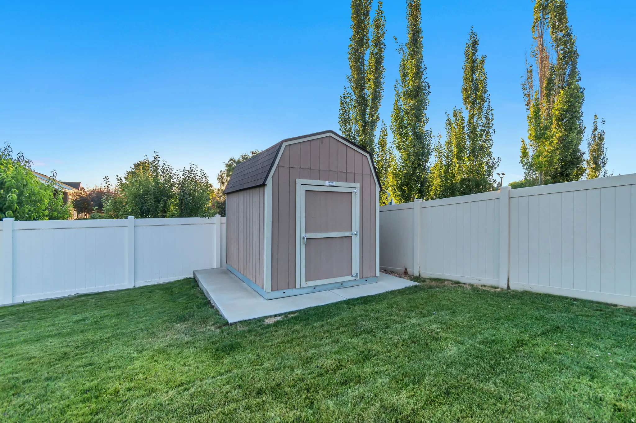 Gable roof storage shed on a concrete pad.