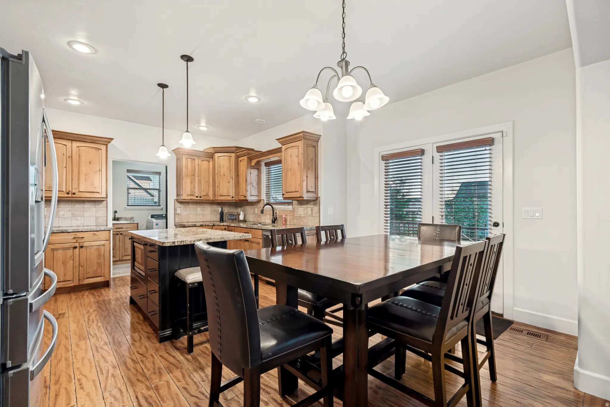 Dining area off of the great room with hardwood flooring, recessed lighting, and a center island featuring a granite countertop.