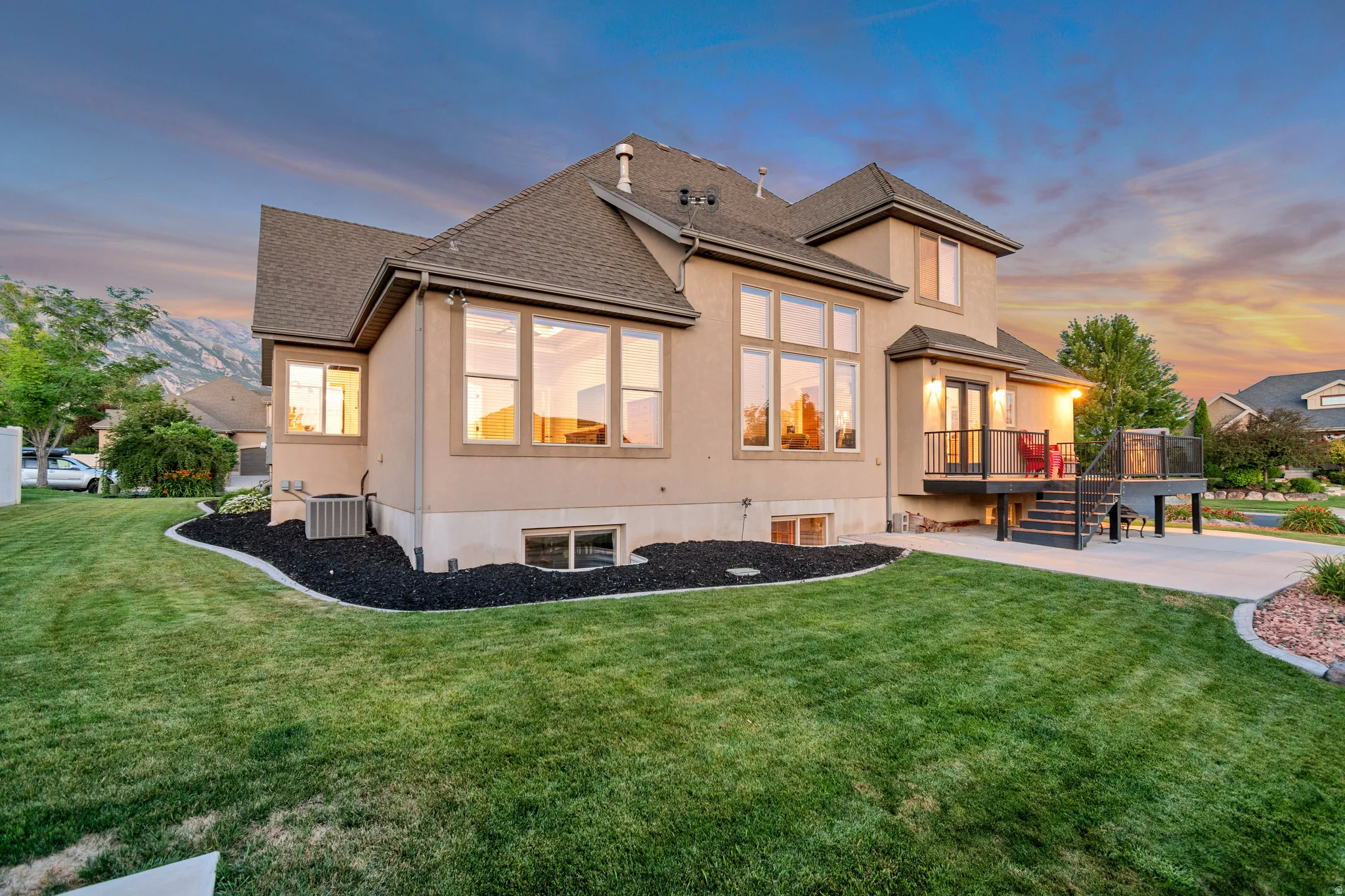 Rear exterior with stucco siding and a multi-level roofline highlighting multiple windows that provide ample lighting throughout the home.