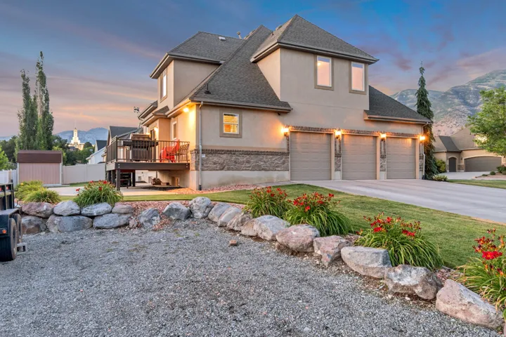 Stucco exterior with stone accents, a three-car garage, a rear deck, and RV parking.