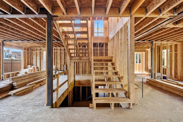 Wood frame construction featuring exposed ceiling joists, wood subflooring, and a multi-level staircase